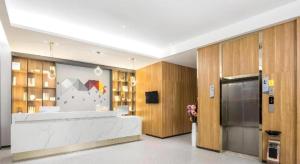 a lobby with a reception desk in a building at Borrman Hotel Suzhou Wujiang Zhongshan North Road Pedestrian Street in Suzhou