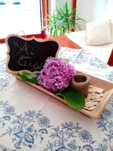a tray with purple flowers and a vase on a table at Appartamento ai Tigli in Noale