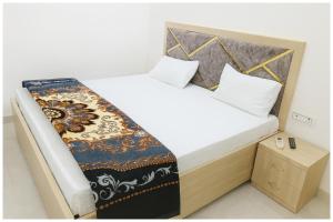 a small bedroom with a bed with a blanket on it at Surya Nagar Hotel M - Residency Near Baba Ji Gurudev Mandir- Sri Krishna Janmabhoomi - Room Service and Parking facilities - Fully Air conditioning Luxuary Room - Top Rated Hotel In Mathura in Mathura +10 photos