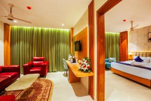 Grand Royal Residency في Pala: غرفة فندق بها سرير وغرفة معيشة +36 صورة