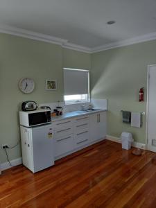 a kitchen with a white refrigerator and a sink at Northwood Bed and Breakfast in Perth