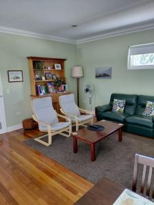 a living room with a green couch and two chairs at Northwood Bed and Breakfast in Perth