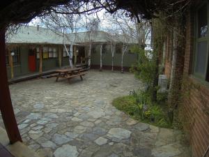 a patio with a picnic table in front of a building at Bunkhouse Motel in Cooma