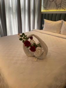 a bouquet of flowers sitting on top of a bed at Apec Mandala Mui Ne by LHG - Sea View, Infinity Pool, Alacarte, 17m to Bàu Trắng Bình Thuận in Mui Ne