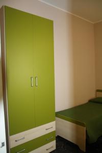 een groene kast in een slaapkamer met een bed bij Casa Vacanza Don Matteo in Villafranca Tirrena