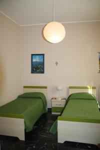 een slaapkamer met 2 bedden en een licht bij Casa Vacanza Don Matteo in Villafranca Tirrena