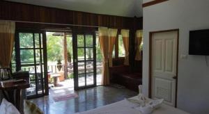 a bedroom with a bed and a sliding glass door at De Bua Valley in Ban Kom