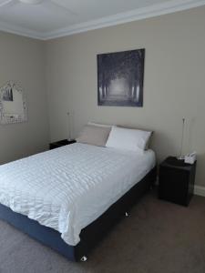 a bedroom with a bed with white sheets and pillows at Northwood Bed and Breakfast in Perth