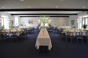 une salle de banquet avec des tables, des chaises et un chercheur de table dans l'établissement Femhøj, à Jægerspris