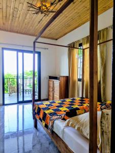 ein Schlafzimmer mit Bett und Balkon in der Unterkunft Villa Natura in Ambondrona