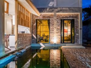 a home with a swimming pool in front of a house at The Arch Casa - Design Hotel Pai ,Free Fast WiFi in Pai