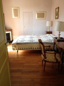 a bedroom with a bed and a desk and a chair at La Maison Févret in Semur-en-Auxois