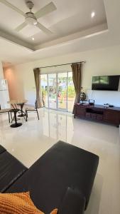 a living room with a couch and a tv at Villa Sun 2 in Amphoe Koh Samui