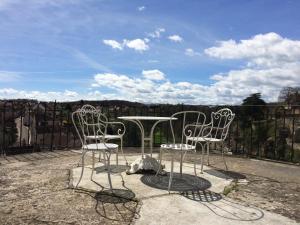 a table and chairs on a patio with a view at La Maison Févret in Semur-en-Auxois