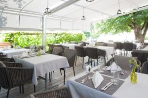 a restaurant with white tables and chairs and trees at Hotel Gasthof Post in Bözen