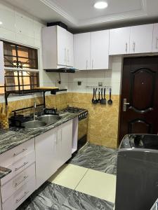 RBZ Apartments في Maryland: مطبخ بخزائن بيضاء ومغسلة