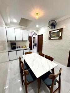 a kitchen with a white table and chairs in a room at Guest House Taman Universiti 3 bedroom in Skudai +9 photos