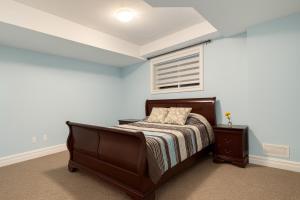 Executive 2BR Lower Suite Private & Spacious Close to USA Border في ويندسور: غرفة نوم بها سرير ونافذة