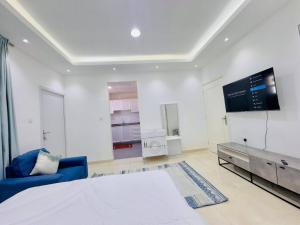 a bedroom with a bed and a tv on the wall at Fully Furnished Studio Near Exibition Center Abu Dhabi in Abu Dhabi