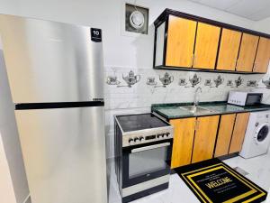 a kitchen with a stainless steel refrigerator and a sink at Fully Furnished Studio Near Exibition Center Abu Dhabi in Abu Dhabi