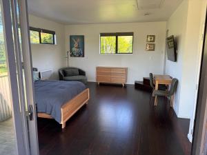 Un dormitorio con una cama, una silla y un escritorio. en Paradise Found at Studio 65, en Hamurana