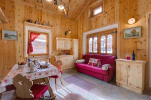 Al Beltram في ليفينو: غرفة معيشة مع أريكة حمراء وطاولة