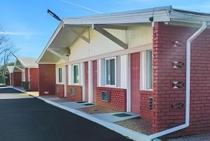 a red brick building with a metal overhang on it at Travelodge by Wyndham Bay Shore Long Island in Bay Shore