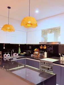 a kitchen with black and white counters and two lights at Solia Villa in Da Nang