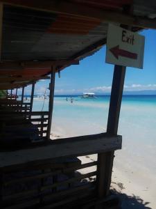 an exit sign on a beach with the ocean at Magic's Place Beach Resort in Saavedra