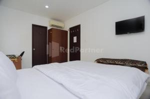 BinongにあるGreen Residence 25 Syariah Karawaci RedPartnerのベッドが2つと壁にテレビがある寝室