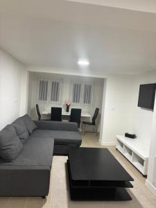 a living room with a couch and a table at Charmant Rez de Jardin 6 p 2 chambres et Parking in Savigny-sur-Orge