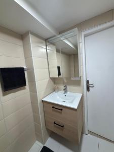a bathroom with a sink and a mirror at Charmant Rez de Jardin 6 p 2 chambres et Parking in Savigny-sur-Orge