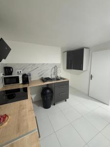 a kitchen with a counter top and a refrigerator at Charmant Rez de Jardin 6 p 2 chambres et Parking in Savigny-sur-Orge +16 photos