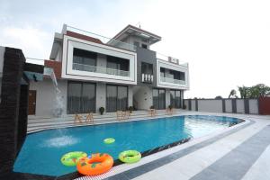 a house with a swimming pool in front of it at Samyukta resort in Gogāpur