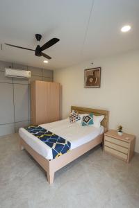 a bedroom with a bed and a ceiling fan at Samyukta resort in Gogāpur