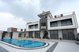 a building with a swimming pool in front of it at Samyukta resort in Gogāpur