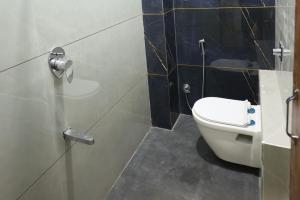 a bathroom with a toilet and a shower stall at Samyukta resort in Gogāpur