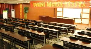 an empty classroom with rows of tables and chairs at GreenTree Inn Lanzhou Yantan Road Express Hotel in Lanzhou