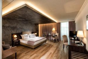 Una habitación de hotel con una cama, un escritorio y sillas. en Wyndham Garden Kassel, en Kassel 25 fotos más