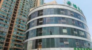 GreenTree Inn Jiangsu Wuxi New District High Speed Rail Station Newland Family Express Hotel في ووشي: مبنى طويل به الكثير من النوافذ