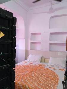 ein Schlafzimmer mit einem Bett mit einer orange-weißen Tagesdecke in der Unterkunft Hotel Diamond Pushkar in Pushkar + 29 Fotos