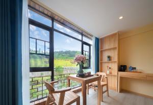 a room with a table and chairs and a large window at Zhangjiajie Oxygen Lodge in Zhangjiajie