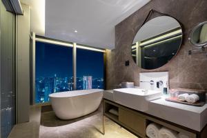 a bathroom with a tub and a sink and a mirror at Atour Hotel Wuhan Hankou Financial Center in Wuhan +25 photos