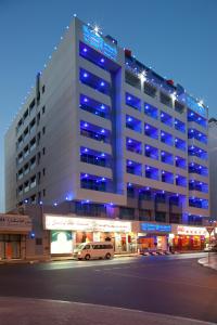 a large building with blue lights on top of it at Rolla Residence Hotel Apartment in Dubai