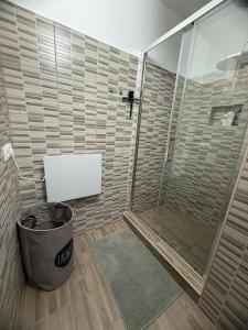 a bathroom with a shower and a trash can at Offline vendégház in Orfű +17 photos