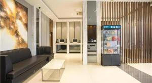 a living room with a couch and a refrigerator at City Comfort Inn Nanning Normal University Mingxiu Metro Station in Nanning