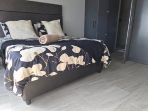 a bedroom with a bed with a black and white blanket at Coastal Cove in Cape Town
