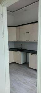 an empty kitchen with white cabinets and a sink at Luxury apartments in Dushanbe