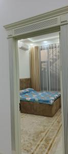 a small bed in a room with a window at Luxury apartments in Dushanbe