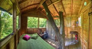 a bedroom in a tree house with a bed in it at Le Chêne Perché in Signy-lʼAbbaye